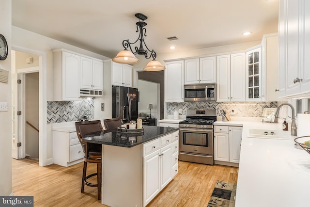 1597 Woodfield Dr, Bethlehem, PA 18015 - kitchen with stainless steel appliances, a sink, backsplash, white cabinets, and a breakfast bar
