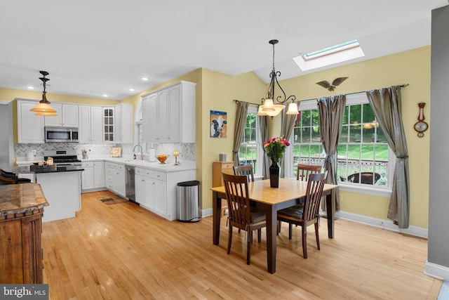 1597 Woodfield Dr, Bethlehem, PA 18015 - dining area with a skylight, light wood-type flooring, baseboards, vaulted ceiling, and recessed lighting