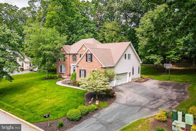 1597 Woodfield Dr, Bethlehem, PA 18015 - view of front of property with asphalt driveway, a garage, a front yard, and brick siding