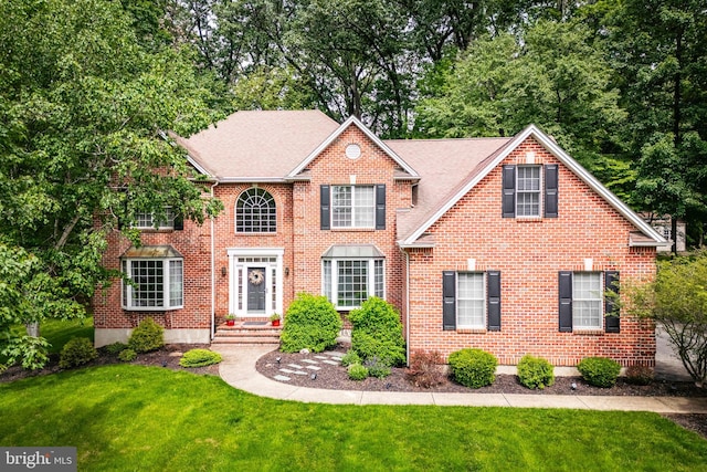 1597 Woodfield Dr, Bethlehem, PA 18015 - colonial-style house featuring a front lawn and brick siding
