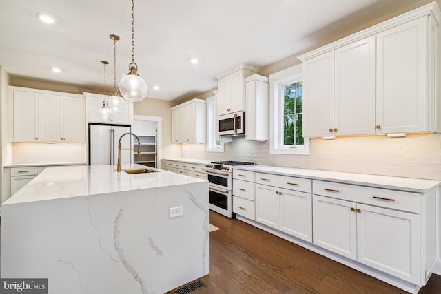 24153 Heartleaf Rd, Frankford, DE 19945 - kitchen featuring high quality appliances, backsplash, white cabinetry, decorative light fixtures, and recessed lighting