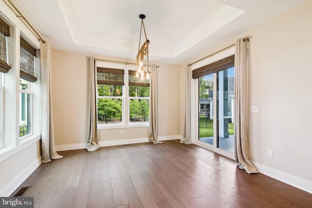 24153 Heartleaf Rd, Frankford, DE 19945 - unfurnished dining area with a raised ceiling, dark wood-style flooring, baseboards, and crown molding