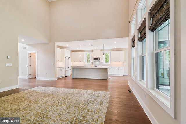 24153 Heartleaf Rd, Frankford, DE 19945 - unfurnished living room with a high ceiling, light wood finished floors, baseboards, and a sink