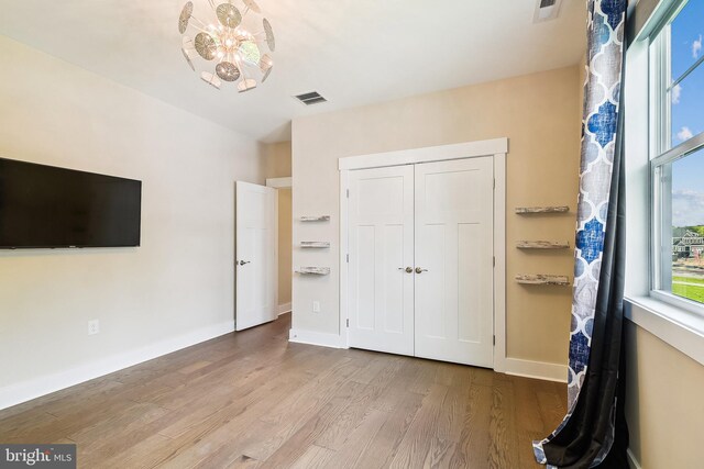24153 Heartleaf Rd, Frankford, DE 19945 - unfurnished bedroom with wood finished floors, baseboards, a closet, and a chandelier
