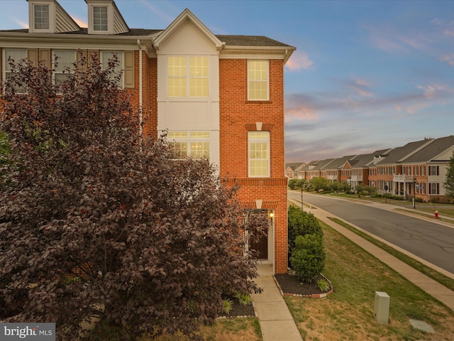 43167 Loudoun Reserve Dr, Ashburn, VA 20148 - property exterior at dusk featuring brick siding, a yard, and a residential view