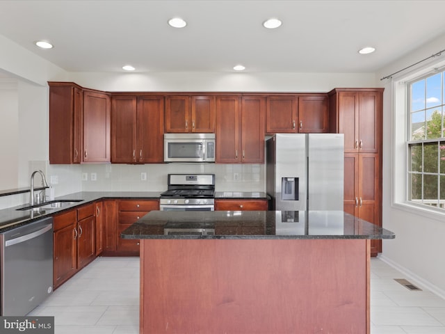 43167 Loudoun Reserve Dr, Ashburn, VA 20148 - kitchen with appliances with stainless steel finishes, a sink, dark stone counters, backsplash, and recessed lighting