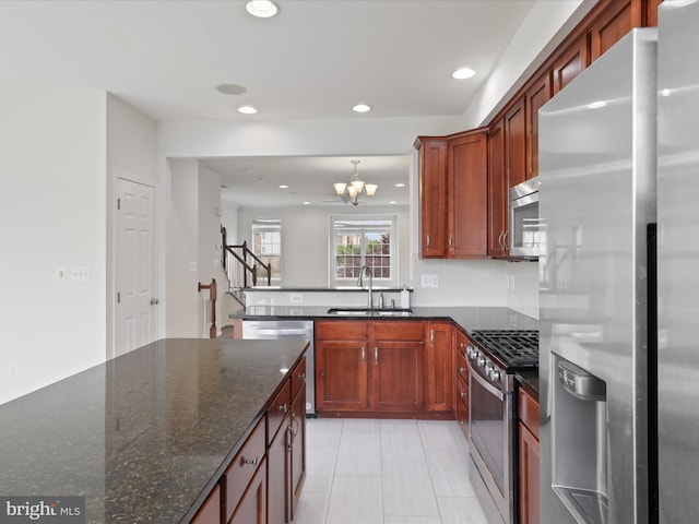 43167 Loudoun Reserve Dr, Ashburn, VA 20148 - kitchen featuring stainless steel appliances, a sink, recessed lighting, a chandelier, and dark stone counters