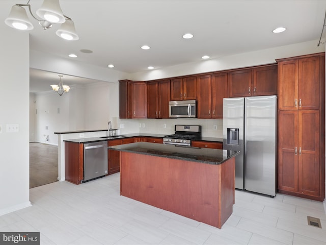 43167 Loudoun Reserve Dr, Ashburn, VA 20148 - kitchen featuring appliances with stainless steel finishes, a chandelier, a peninsula, a sink, and a kitchen island