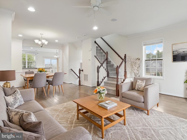 43167 Loudoun Reserve Dr, Ashburn, VA 20148 - living area with crown molding, a chandelier, light wood-style floors, stairs, and recessed lighting