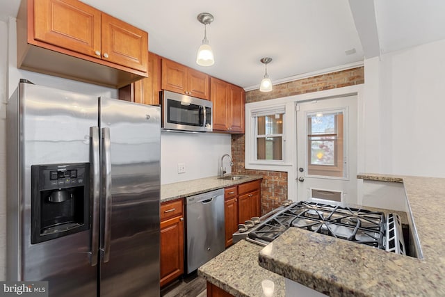2802 Bruce Pl SE, Washington, DC 20020 - kitchen featuring stainless steel appliances, a sink, brick wall, brown cabinets, and light stone counters
