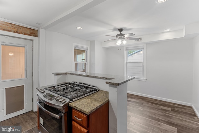 2802 Bruce Pl SE, Washington, DC 20020 - kitchen featuring stainless steel gas range oven, stone countertops, dark wood-style flooring, baseboards, and ceiling fan