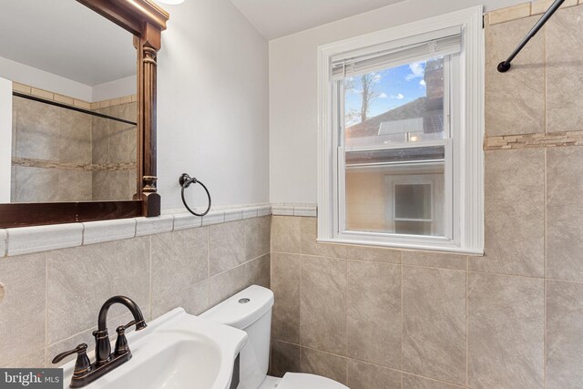 2802 Bruce Pl SE, Washington, DC 20020 - full bathroom with a sink, toilet, a tile shower, and tile walls