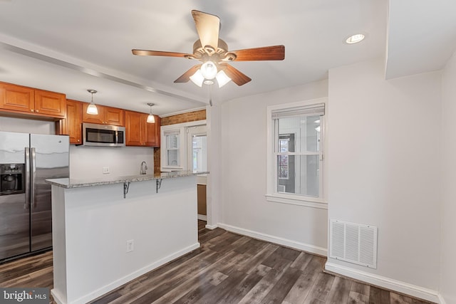 2802 Bruce Pl SE, Washington, DC 20020 - kitchen featuring appliances with stainless steel finishes, a ceiling fan, dark wood-type flooring, brown cabinets, and recessed lighting