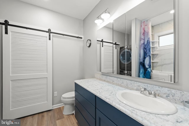 1419 Ramseur Ln, Winchester, VA 22601 - bathroom with vanity, toilet, stacked washing machine and dryer, a shower with shower curtain, and wood finished floors