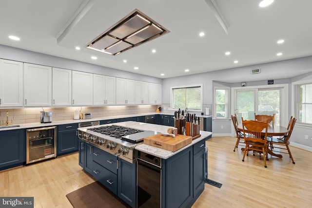1419 Ramseur Ln, Winchester, VA 22601 - kitchen with stainless steel gas stovetop, blue cabinetry, light countertops, white cabinetry, and recessed lighting