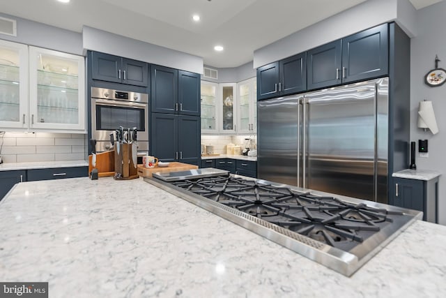 1419 Ramseur Ln, Winchester, VA 22601 - kitchen featuring stainless steel appliances, decorative backsplash, glass insert cabinets, light stone countertops, and recessed lighting
