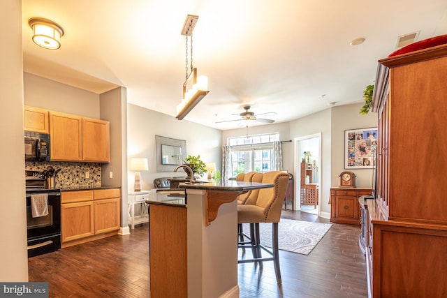 1000 Fountainview Cir Unit 304, Newark, DE 19713 - kitchen with black appliances, a ceiling fan, a breakfast bar, dark countertops, and dark wood-type flooring