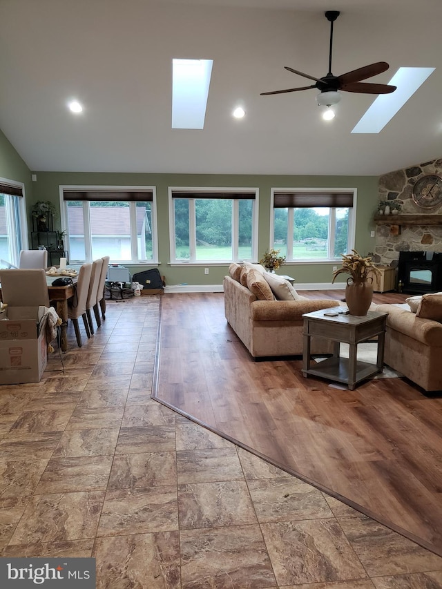 4010 Conowingo Rd, Darlington, MD 21034 - living area with a skylight, vaulted ceiling, ceiling fan, a stone fireplace, and baseboards