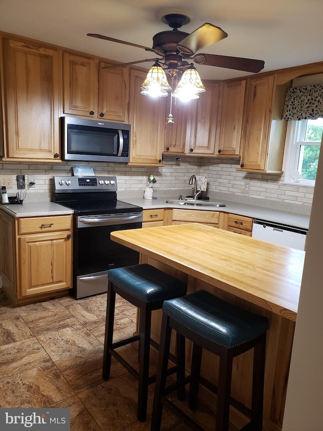 4010 Conowingo Rd, Darlington, MD 21034 - kitchen with appliances with stainless steel finishes, a sink, decorative backsplash, a ceiling fan, and butcher block countertops