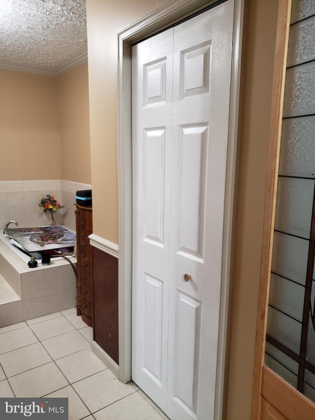 4010 Conowingo Rd, Darlington, MD 21034 - bathroom featuring tile patterned floors, ornamental molding, tiled bath, a textured ceiling, and a closet