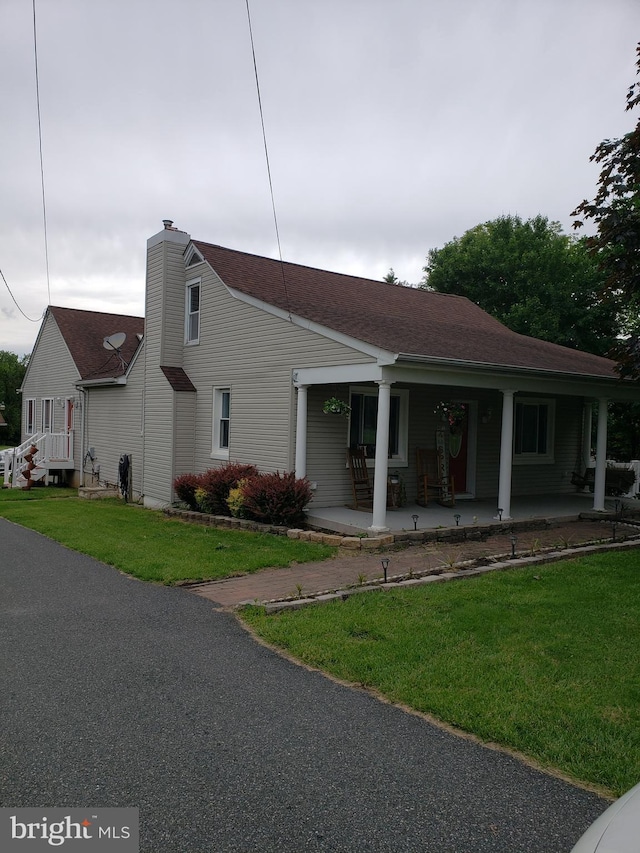 4010 Conowingo Rd, Darlington, MD 21034 - view of front facade featuring covered porch, a front yard, a chimney, and roof with shingles
