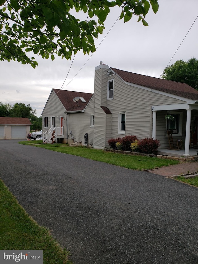 4010 Conowingo Rd, Darlington, MD 21034 - view of side of home with a chimney, a porch, a garage, an outbuilding, and roof with shingles