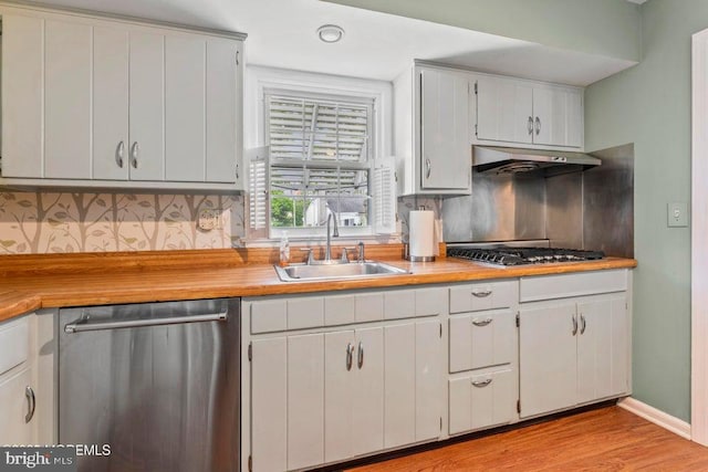 605 Oak Ter, Point Pleasant Boro, NJ 08742 - kitchen with stainless steel appliances, under cabinet range hood, a sink, tasteful backsplash, and light wood-type flooring