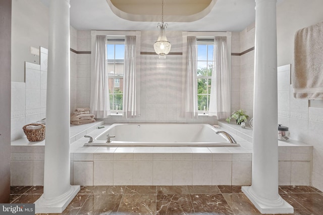 3310 Hudson St, Baltimore, MD 21224 - bathroom featuring decorative columns, plenty of natural light, a bath, tile walls, and marble finish flooring