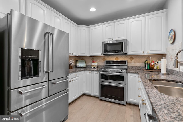 8820 Shining Oceans Way Unit 407, Columbia, MD 21045 - kitchen with stainless steel appliances, white cabinets, dark stone countertops, light wood finished floors, and recessed lighting