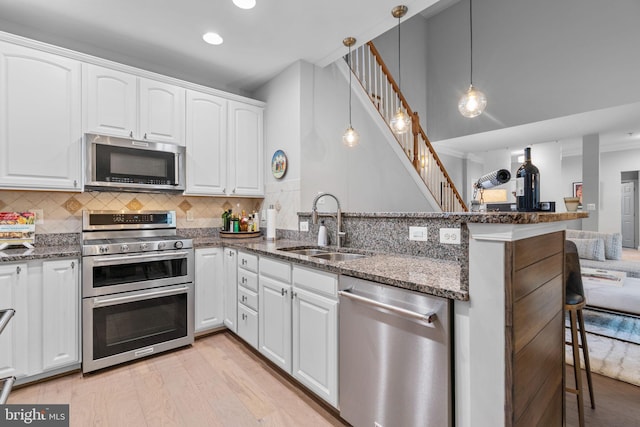 8820 Shining Oceans Way Unit 407, Columbia, MD 21045 - kitchen featuring stainless steel appliances, a peninsula, white cabinetry, a kitchen breakfast bar, and recessed lighting