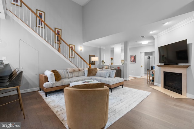 8820 Shining Oceans Way Unit 407, Columbia, MD 21045 - living area with ornamental molding, wood finished floors, stairs, a fireplace with flush hearth, and recessed lighting