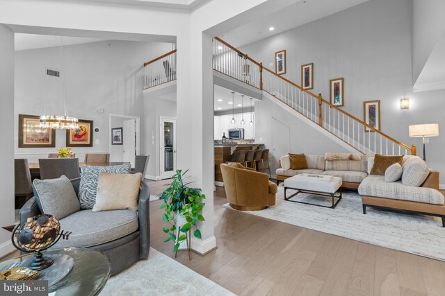 8820 Shining Oceans Way Unit 407, Columbia, MD 21045 - living room with a high ceiling, wood finished floors, a chandelier, recessed lighting, and stairs