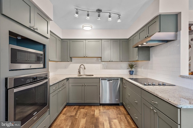 1328 Hollow Glen Ct, Curtis Bay, MD 21226 - kitchen featuring stainless steel appliances, a sink, tasteful backsplash, light wood-type flooring, and under cabinet range hood