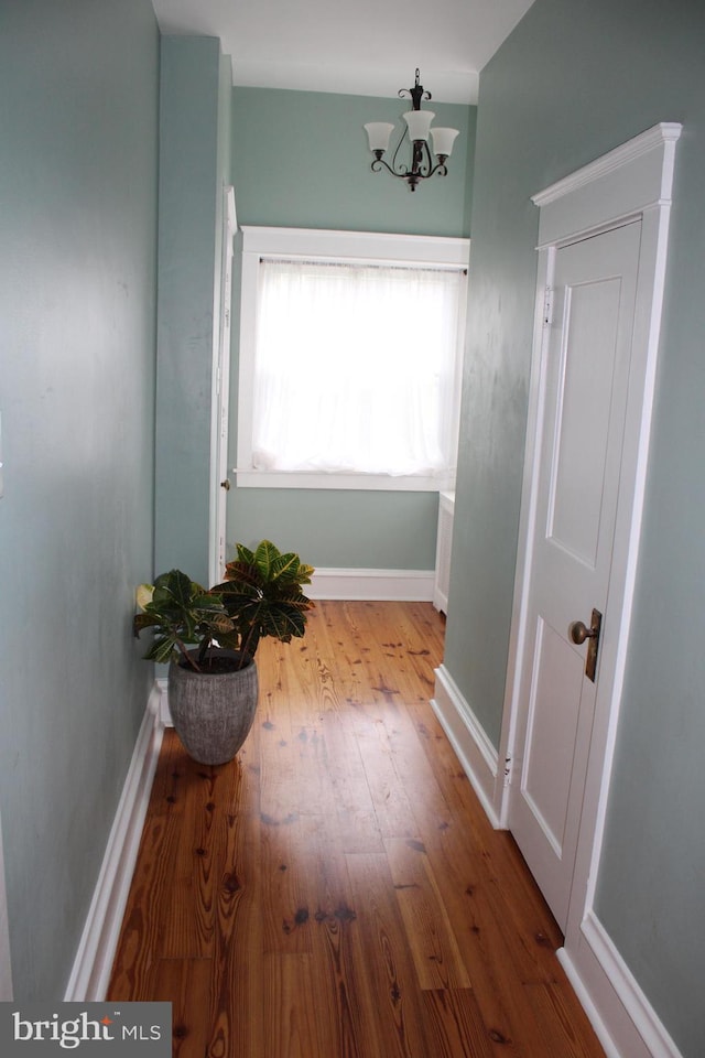 527 N 25th St, Reading, PA 19606 - hallway with a chandelier, wood finished floors, and baseboards