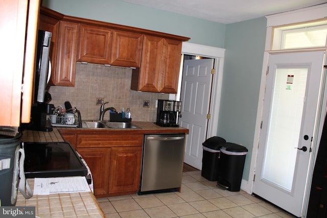 527 N 25th St, Reading, PA 19606 - kitchen with stainless steel dishwasher, tile counters, a sink, backsplash, and light tile patterned flooring