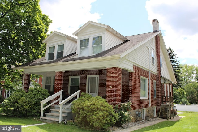 527 N 25th St, Reading, PA 19606 - view of front facade with a chimney, brick siding, and a front lawn
