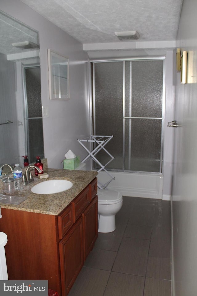 527 N 25th St, Reading, PA 19606 - bathroom featuring vanity, toilet, combined bath / shower with glass door, and a textured ceiling