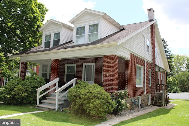 527 N 25th St, Reading, PA 19606 - view of front of home featuring a chimney, a front yard, and brick siding