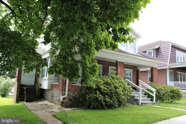 527 N 25th St, Reading, PA 19606 - view of property hidden behind natural elements featuring a front lawn, brick siding, and stairs
