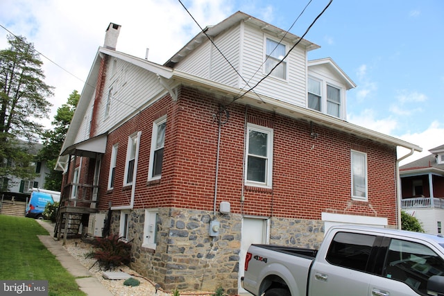 527 N 25th St, Reading, PA 19606 - view of home's exterior with washer / clothes dryer, a chimney, and brick siding