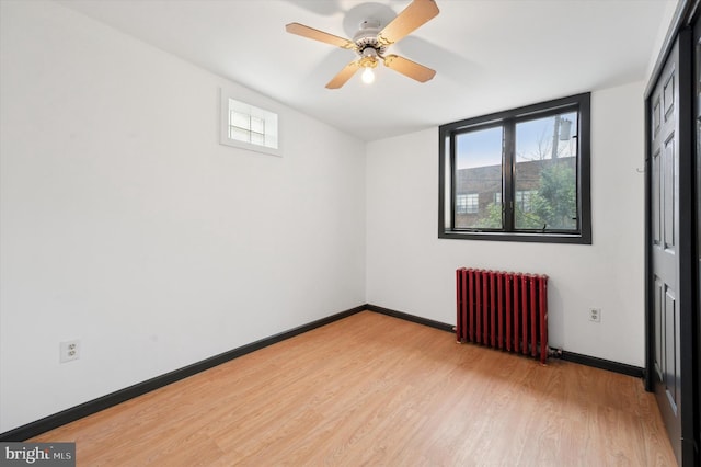 913 Tasker St, Philadelphia, PA 19148 - unfurnished bedroom with radiator, light wood-style floors, multiple windows, and baseboards