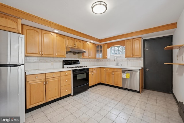 913 Tasker St, Philadelphia, PA 19148 - kitchen with stainless steel appliances, under cabinet range hood, light countertops, a sink, and decorative backsplash