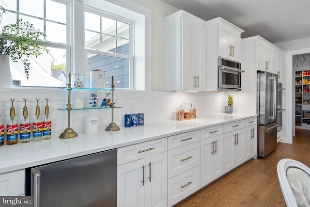 18234 Highwood Dr, Rehoboth Beach, DE 19971 - kitchen featuring high quality fridge, healthy amount of natural light, white cabinetry, and decorative backsplash