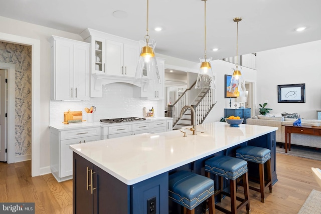 18234 Highwood Dr, Rehoboth Beach, DE 19971 - kitchen with light wood-type flooring, light countertops, white cabinets, glass insert cabinets, and recessed lighting