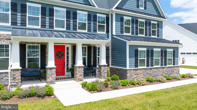 18234 Highwood Dr, Rehoboth Beach, DE 19971 - craftsman-style home featuring a standing seam roof, stone siding, a porch, and metal roof