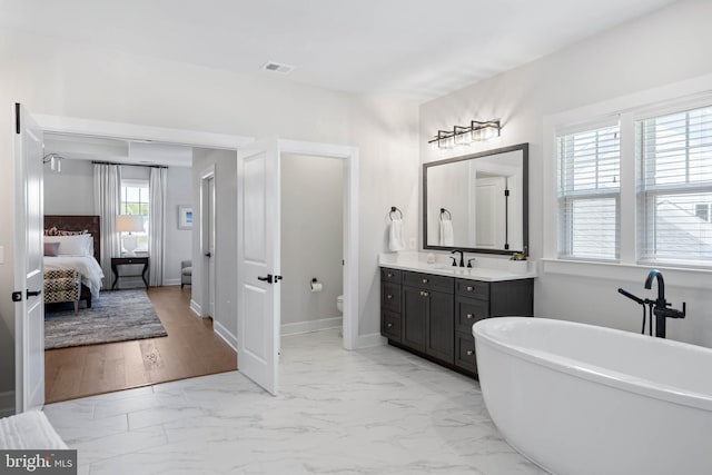 18234 Highwood Dr, Rehoboth Beach, DE 19971 - ensuite bathroom featuring marble finish flooring, a freestanding bath, toilet, vanity, and baseboards