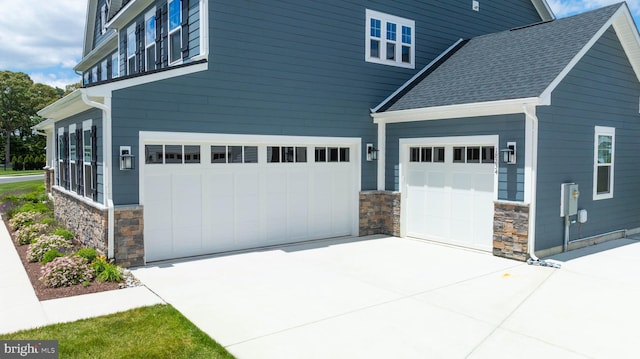 18234 Highwood Dr, Rehoboth Beach, DE 19971 - view of property exterior with stone siding, an attached garage, driveway, and a shingled roof
