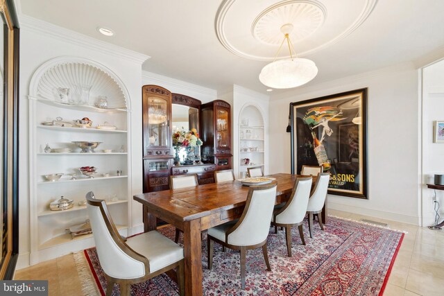 9791 Pintail Pl, Saint Michaels, MD 21663 - dining space with built in shelves, crown molding, light tile patterned flooring, and baseboards