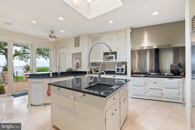 9791 Pintail Pl, Saint Michaels, MD 21663 - kitchen featuring a kitchen island with sink, recessed lighting, light tile patterned floors, a skylight, and ceiling fan