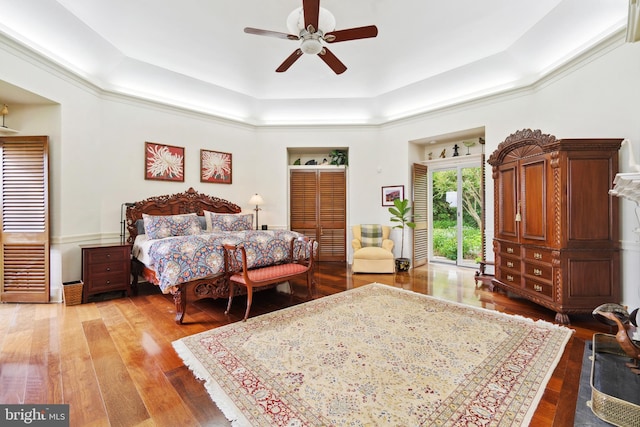 9791 Pintail Pl, Saint Michaels, MD 21663 - bedroom with a tray ceiling, light wood-style flooring, and a ceiling fan